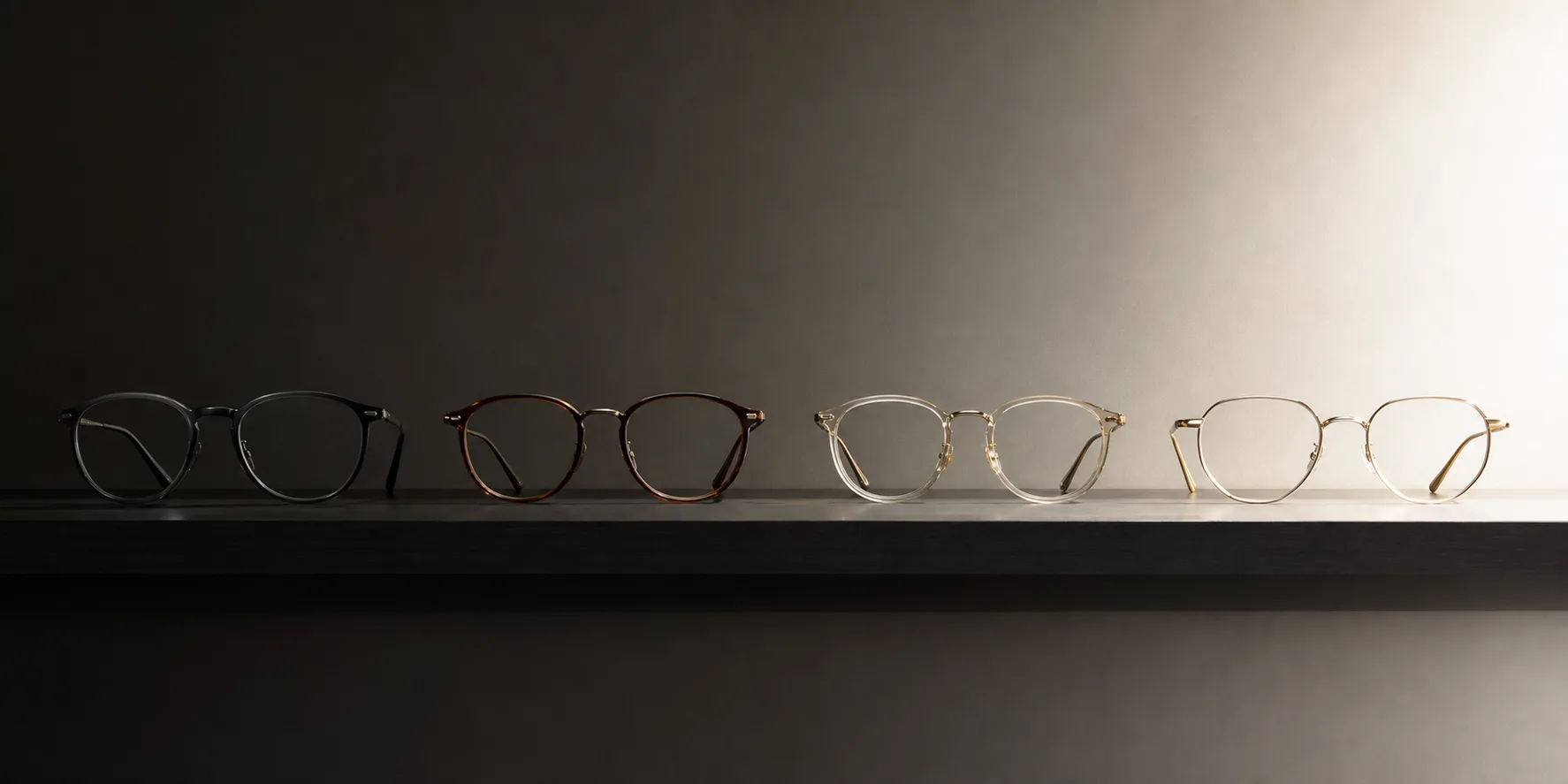 Four pairs of sleek display glasses arranged in a row on a dark shelf with graduated lighting