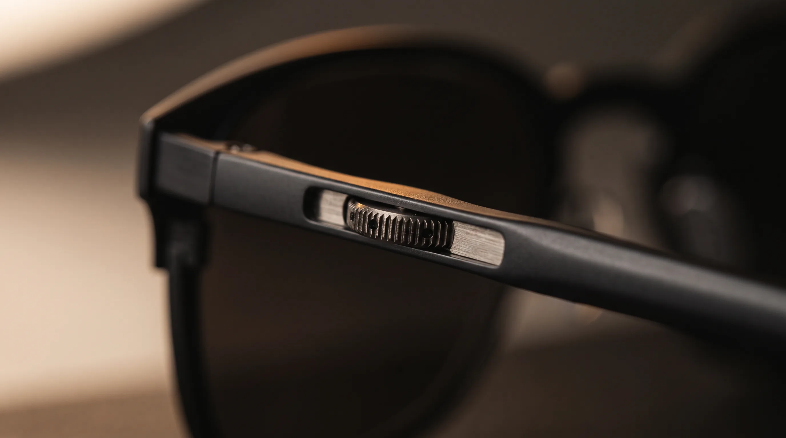 Macro of an unmarked knurled focus dial on the temple arm of display glasses